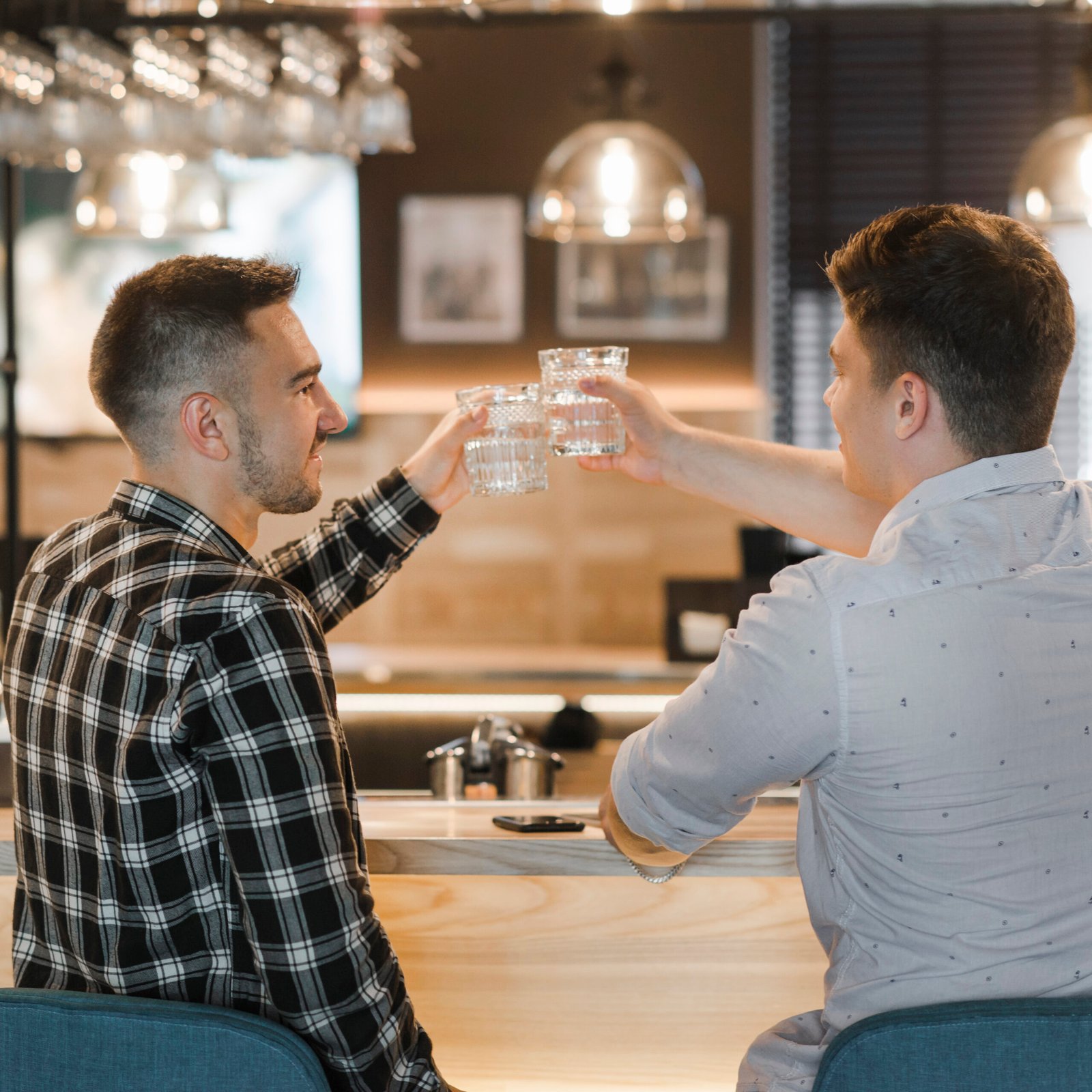 Home rear view young man toasting drinks bar